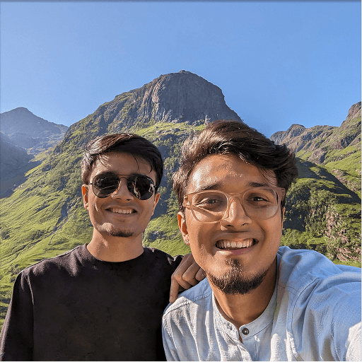 Ashwin and his brother smiling in front of the Scottish highlands